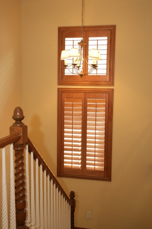 Wooden plantation shutters in tan staircase.